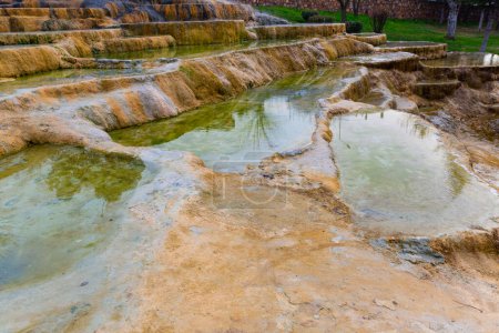Unique rust coloured travertine terraces with mineral hot water of Karahyit Red Springs, Denizli Province, Turkey