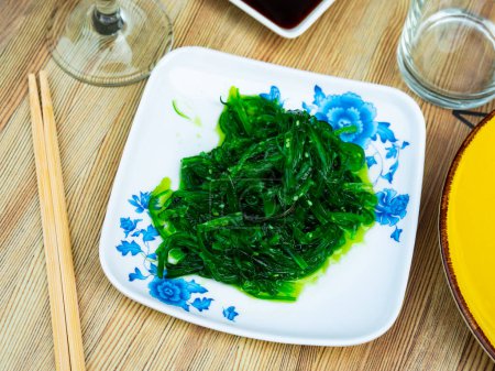 Ensalada de algas japonesas goma wakame con semillas de sésamo servidas en bandeja