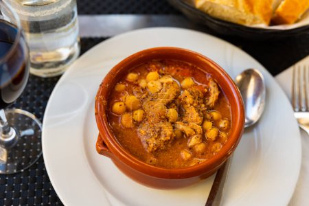 Delicious braised tripe served with chorizo and chickpeas in bowl..