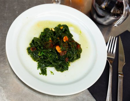 Catalan Spinach served on table with decanter of red wine