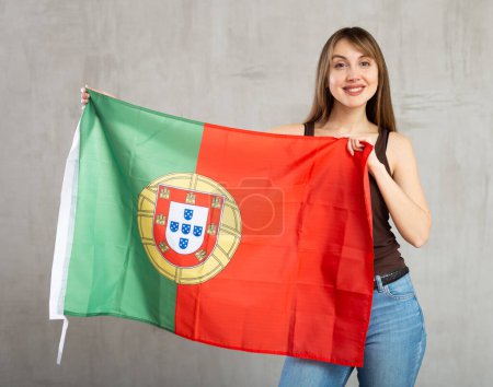 Junge hübsche Frau posiert fröhlich mit portugiesischer Flagge