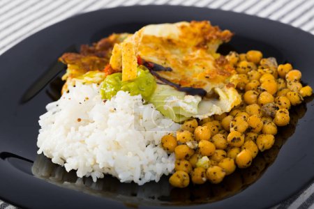Image of chicken thighs with cabbage leaves in batter, cheakpea and rice at plate