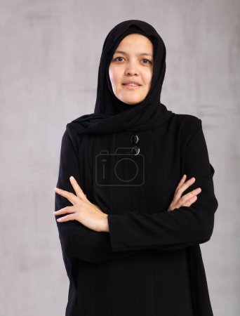 Positive young muslim woman wearing a hijab looking at the camera studio