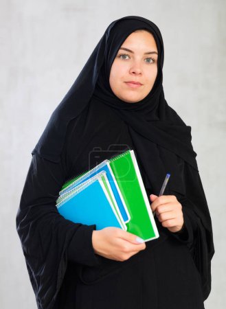 estudiante enfocada chica con pila de grandes cuadernos multicolores. Educación en la escuela secundaria concepto universitario. plano de estudio