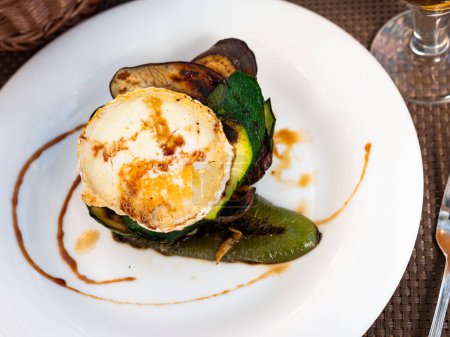 Appetizing zucchini and eggplant timbale with goat cheese served on plate