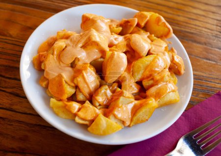 Crispy fried Patatas bravas traditionally served with spicy sauces to beer. Spanish tapa
