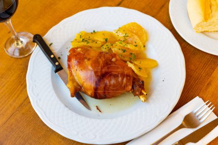 Leckeres spanisches Gericht ist Toston asado, aus Schweinebraten mit einer appetitlich knusprigen Kruste, serviert mit Kartoffeln und.. mit Kräutern bestreut