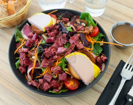 Portion köstlicher Perigord-Salat aus getrockneter Entenbrust, Toast mit Gänseleber, Walnüssen und Muskelmagen.