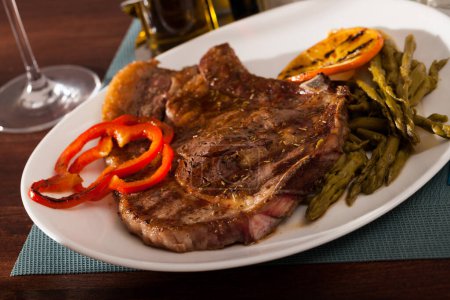 Spicy roasted veal steak with pickled asparagus and grilled orange