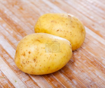 Frisch gewaschene Kartoffeln auf einem Holztisch. Zutaten zum Kochen