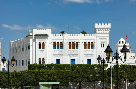 Edificio de la Oficina de Religiones en la capital tunecina en la Plaza Kasbah. Edificio blanco de estilo árabe destaca vívidamente sobre fondo de cielo azul y setos verdes de arbustos ornamentales.