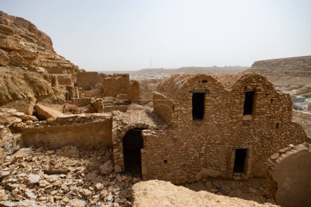 Strahlend sonniger Tag in rauen Ruinen des Berberdorfes Ghomrassen, Tatahouine. Blick auf Häuser und Nebengebäude, Moscheen in arabischer Kleinstadt