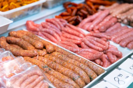 Closeup of appetizing chorizo, morcilla, butifarra and chistorra sausages offered for sale in showcase. Large assortment of butchery produce