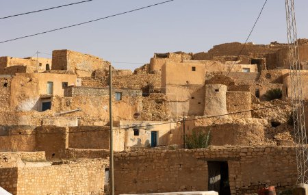 Sonnendurchflutete, verwitterte Steinhäuser von Tamezret, einem alten Berberdorf im Gouvernement Gabes, das sich in die trockene tunesische Landschaft einfügt