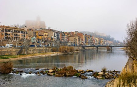 View of bridge over Segre River in Catalonia - town of Balaguer. Foggy morning in ancient European city