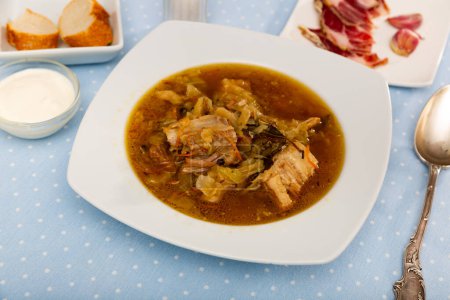 Cocina rusa. Shchi nacional popular cocinado de chucrut en caldo de champiñones con carne de cerdo servida con crema agria