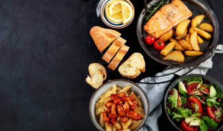 Set of various main dishes. Different healthy main courses, meat and fish dishes, pasta, salads, sauces, bread and vegetables on a dark background. Top view. Panorama with copy space.