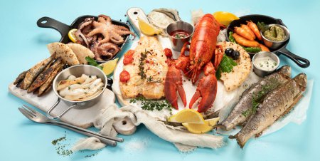 Téléchargez les photos : Divers plats de fruits de mer et de poissons. Concept d'alimentation saine sur fond bleu - en image libre de droit
