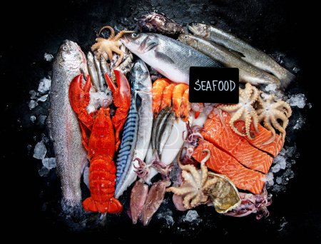 Photo for Fresh fish and seafood assortment on black background, fish market. Healthy diet eating concept. Top view., copy space. - Royalty Free Image