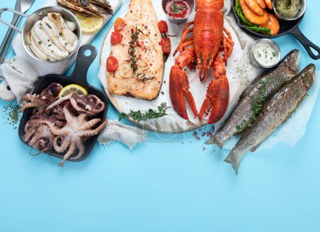 Foto de Varios platos de mariscos y peces. Concepto de comida saludable sobre fondo azul, vista superior, espacio para copiar - Imagen libre de derechos