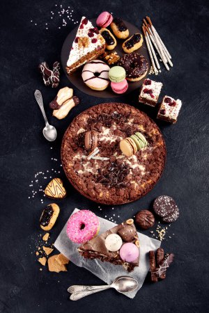 Photo for Assortment of confectionery, different types desserts on dark table. Top view, copy space - Royalty Free Image