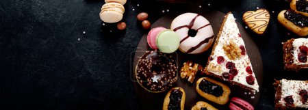 Photo for Assortment of confectionery, different types desserts on dark table. Top view, copy space Panorama, banner - Royalty Free Image