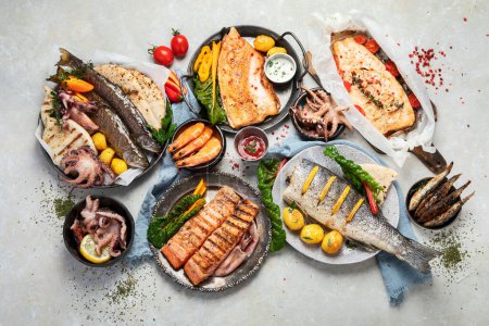 Foto de Bandeja de mariscos. Surtido de deliciosos mariscos con verduras sobre un fondo gris. Vista superior. - Imagen libre de derechos