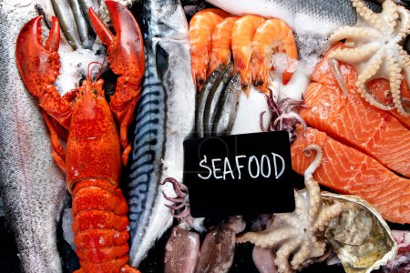 Téléchargez les photos : Assortiment de poissons et fruits de mer frais sur fond noir, marché aux poissons. Une alimentation saine concept de manger. Vue du dessus. - en image libre de droit