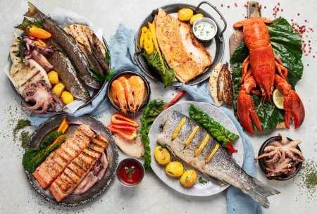 Photo for Seafood platter. Assorted delicious seafood with vegetables on a grey background. Top view. - Royalty Free Image