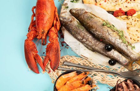 Téléchargez les photos : Divers plats de fruits de mer et de poissons. Concept d'alimentation saine sur fond bleu, vue du dessus, espace de copie - en image libre de droit