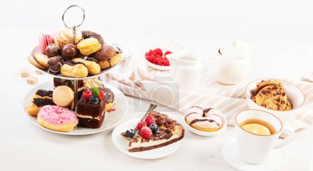 Foto de Soporte para pasteles con macarrones, mini pasteles, galletas para el té. Panorama con espacio de copia. - Imagen libre de derechos
