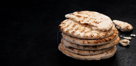 Photo for Pita bread isolated on a dark background. Traditional and typical food of Arabic cuisine. Top view. Panorama. - Royalty Free Image