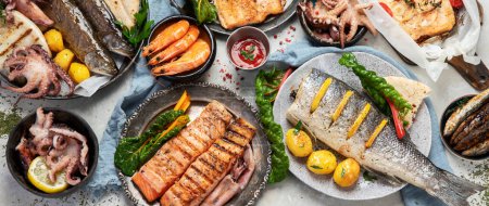 Photo for Seafood platter. Assorted delicious seafood with vegetables on a grey background. Top view. Panorama. - Royalty Free Image