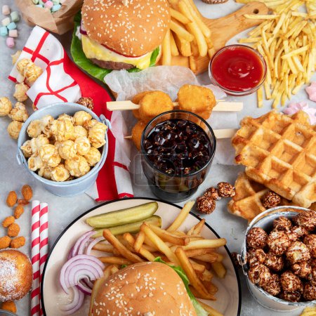 Foto de Various of american food, French fries, hamburgers, nuggets, hotdog, chips, popcorn, sauces on a white background, top view. - Imagen libre de derechos