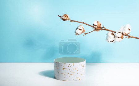 Photo for Podium for beauty product promotion, spring cotton twig on light blue. Empty showcase for cosmetics presentation. Top view. - Royalty Free Image