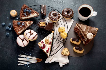 Photo for Table with various cookies, donuts, cakes, cheesecakes on dark background.  Delicious dessert table. Top view, flat lay - Royalty Free Image