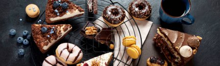 Photo for Table with various cookies, donuts, cakes, cheesecakes on dark background.  Delicious dessert table. Top view, flat lay, copy space. Panorama, banner - Royalty Free Image