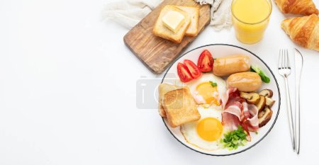 Foto de Desayuno inglés con huevo frito, salchicha, tocino y tostadas sobre fondo blanco, vista superior, spase de copia - Imagen libre de derechos