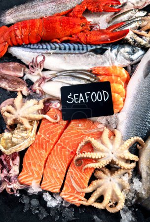 Foto de Surtido de pescados y mariscos frescos sobre fondo negro, mercado de pescado. Concepto de alimentación saludable. Vista superior - Imagen libre de derechos