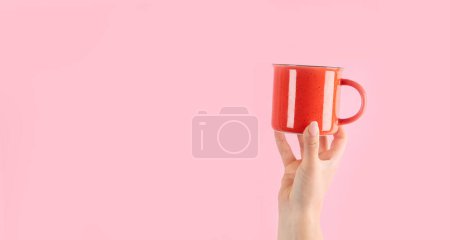 Téléchargez les photos : Bras levés tenant une tasse de café sur fond rose. Photo concept. Vue de face - en image libre de droit