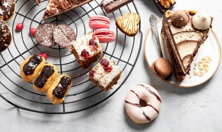 Téléchargez les photos : Table avec divers biscuits, beignets, gâteaux et tasses à café sur fond clair. Vue du dessus. - en image libre de droit