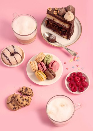 Téléchargez les photos : Table avec divers biscuits, beignets, gâteaux, gâteaux au fromage et tasses à café sur fond rose. Délicieuse table à dessert. Vue de dessus, plan plat - en image libre de droit