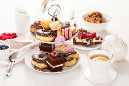 Cake stand with macaroons, mini cakes, cookies for tea.