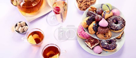 Photo for Traditional English tea. Afternoon tea with  selection of sweets  on violet background. Holiday concept - Royalty Free Image
