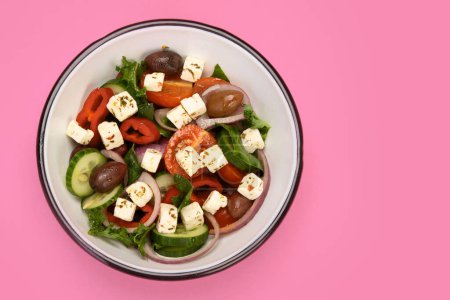Téléchargez les photos : Salade grecque sur fond de couleur. Nourriture traditionnelle. Concept photo créatif. Vue du dessus, espace de copie - en image libre de droit