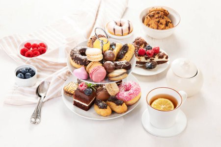 Foto de Soporte para pasteles con macarrones, mini pasteles, galletas para el té. - Imagen libre de derechos