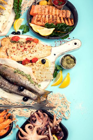 Téléchargez les photos : Divers plats de fruits de mer et de poissons. Concept d'alimentation saine sur fond bleu, vue du dessus, espace de copie - en image libre de droit