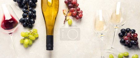 Foto de Degustación de vinos. Una foto aérea de vasos de vino tinto y blanco con una botella, uvas, y un corcho vintage y corchos, disparados desde arriba sobre un fondo claro. Panorama. - Imagen libre de derechos