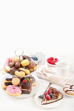 Foto de Soporte para pasteles con macarrones, mini pasteles, galletas para el té. - Imagen libre de derechos