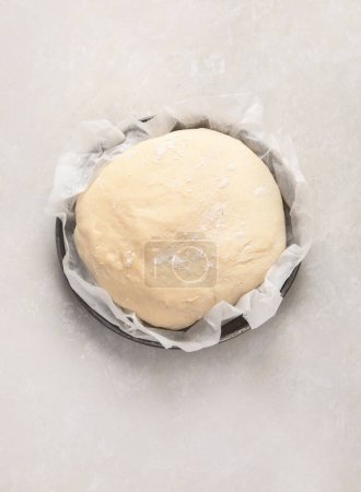 Photo for Raw dough pastry in a bowl on neutral background. Homemade bio food concept. Top view, copy space - Royalty Free Image